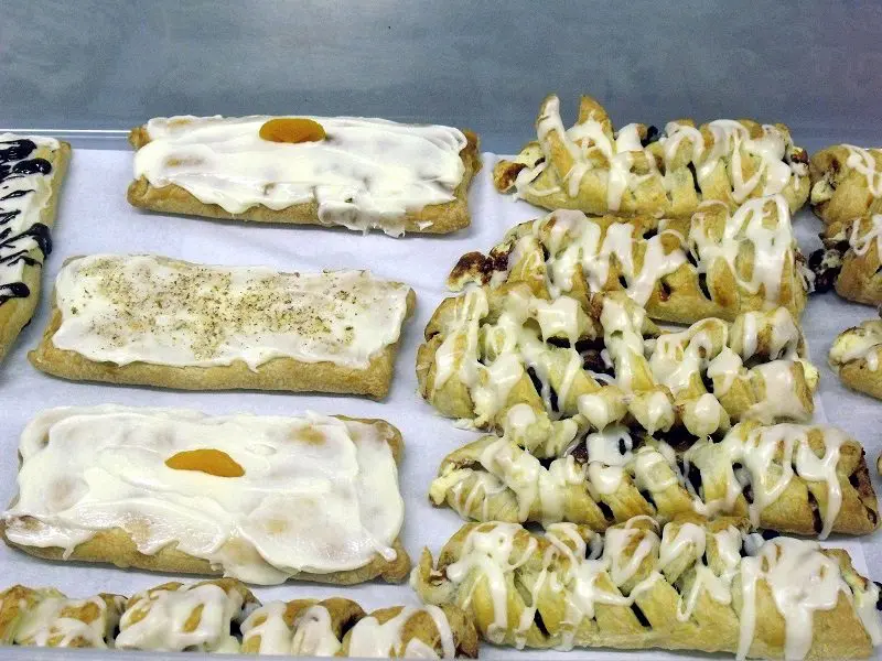 A variety of pastries are lined up on the counter.
